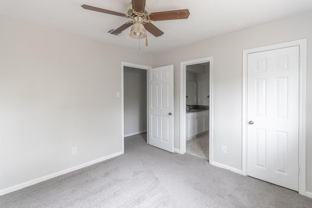 unfurnished bedroom with ceiling fan, light colored carpet, and connected bathroom