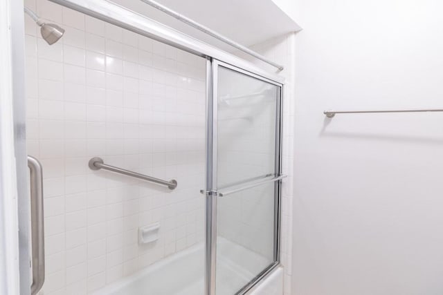 bathroom featuring combined bath / shower with glass door