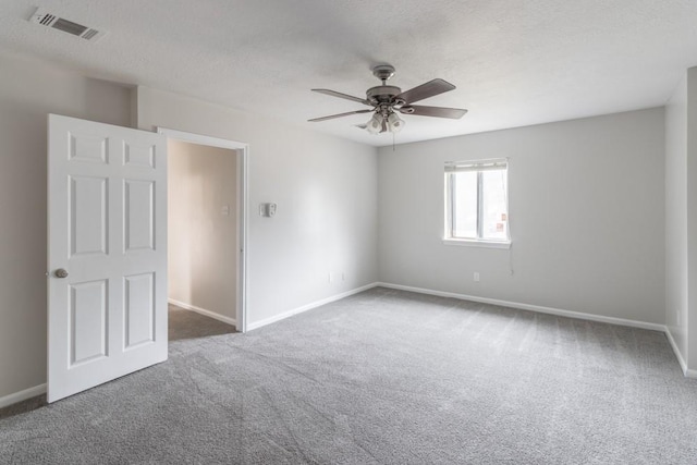 carpeted empty room with ceiling fan and a textured ceiling