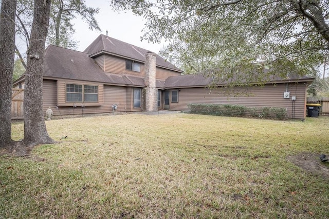 rear view of property with a lawn