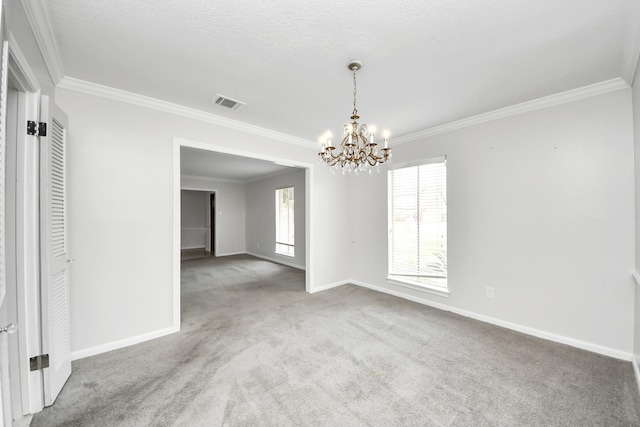 empty room featuring crown molding, carpet flooring, a textured ceiling, and a notable chandelier