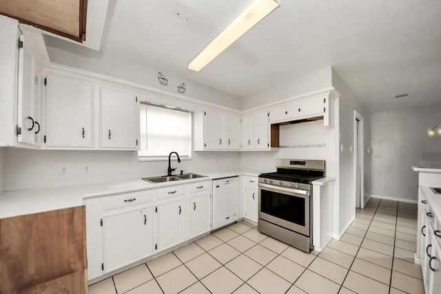 kitchen with light tile patterned flooring, stainless steel gas stove, white cabinetry, dishwasher, and sink