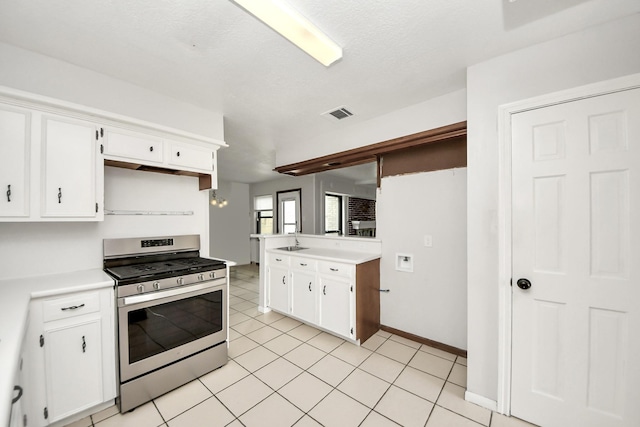 kitchen with white cabinetry, light tile patterned floors, sink, and stainless steel gas stove