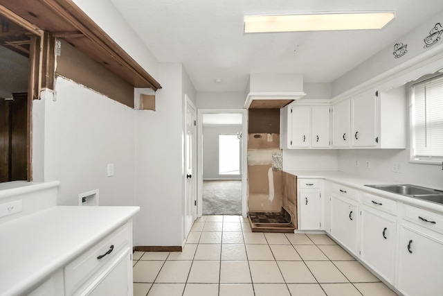 kitchen featuring white cabinetry, sink, and light tile patterned flooring