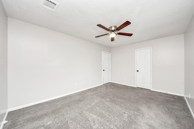 carpeted empty room featuring ceiling fan and a textured ceiling