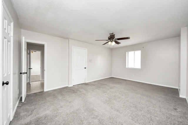 carpeted empty room featuring ceiling fan and a textured ceiling