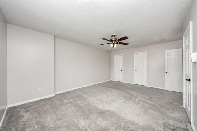 carpeted spare room with ceiling fan and a textured ceiling