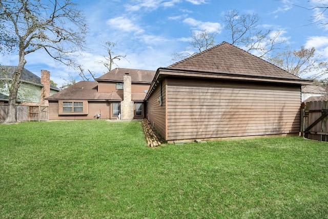 rear view of house featuring a lawn