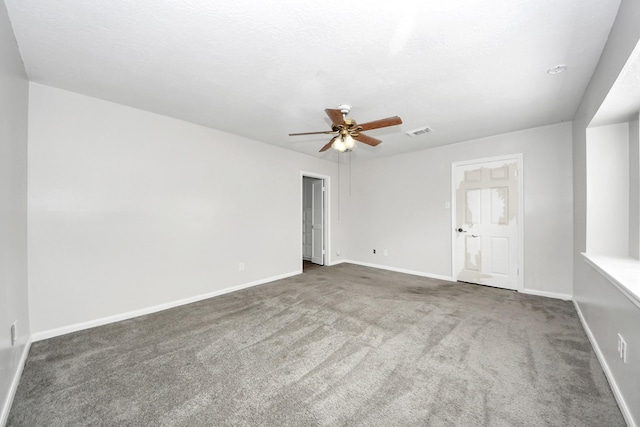 carpeted spare room featuring ceiling fan and a textured ceiling