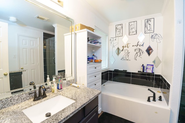 bathroom with vanity, crown molding, and a bathtub