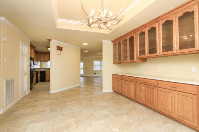 kitchen with hanging light fixtures, crown molding, a notable chandelier, and a tray ceiling