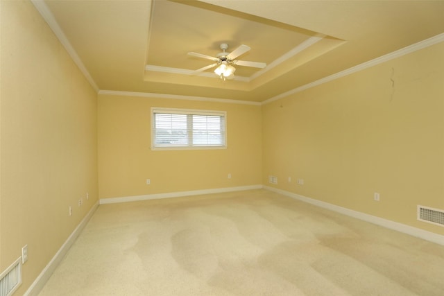 unfurnished room featuring ceiling fan, carpet flooring, ornamental molding, and a tray ceiling