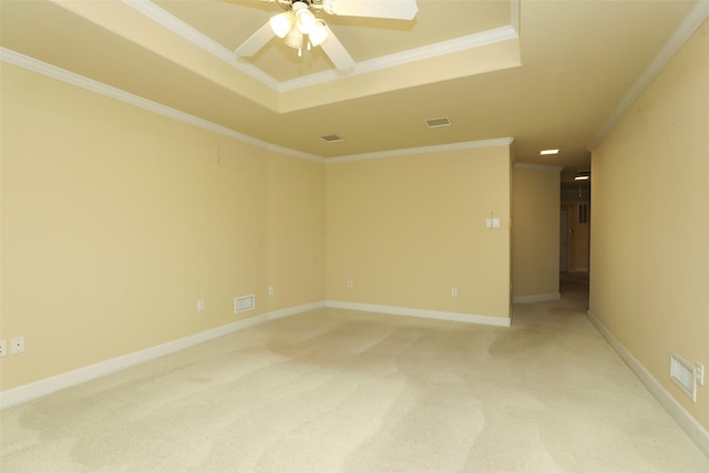 unfurnished room with ornamental molding, carpet flooring, ceiling fan, and a tray ceiling