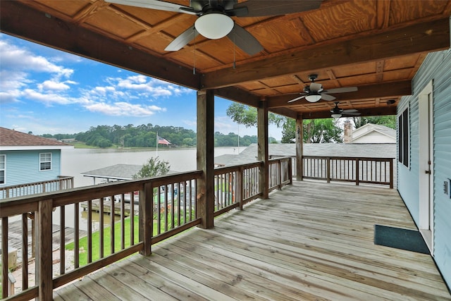 wooden terrace with a water view and ceiling fan