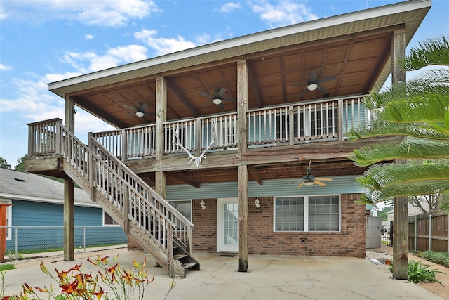 rear view of property featuring ceiling fan and a patio area