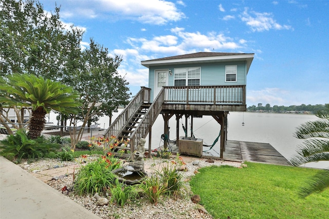 view of front of home with a water view, a dock, a front yard, and central air condition unit