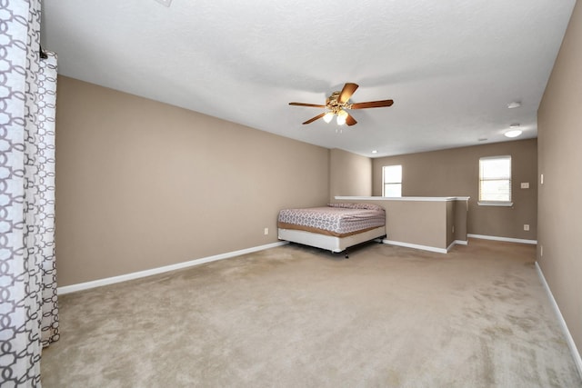 unfurnished bedroom featuring a textured ceiling, carpet floors, and ceiling fan