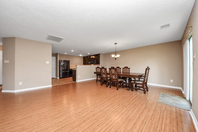 dining area featuring a chandelier and light hardwood / wood-style floors