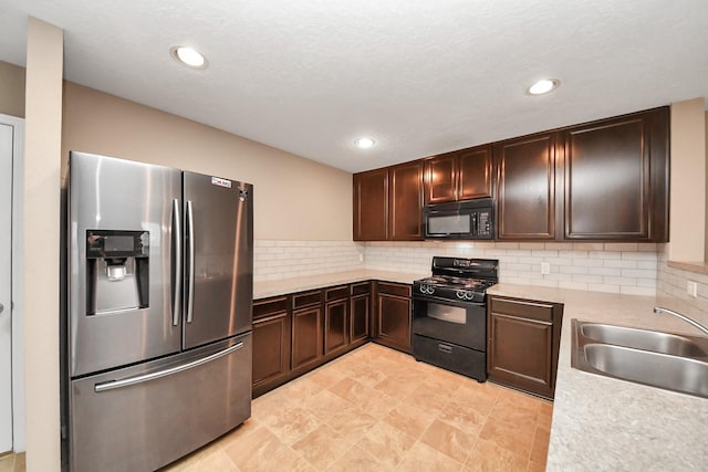 kitchen with sink, decorative backsplash, dark brown cabinetry, and black appliances