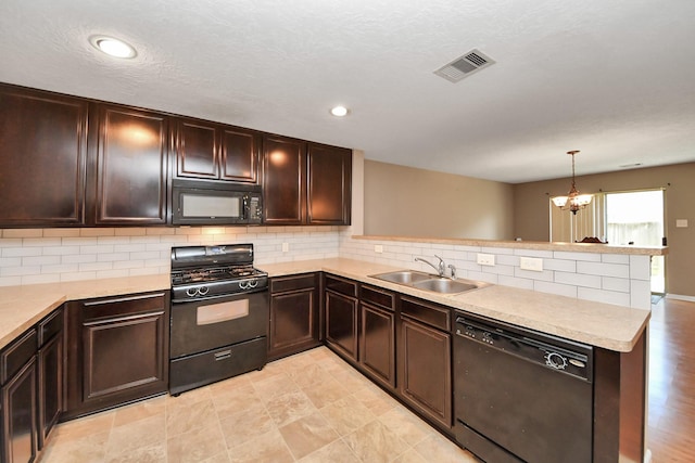 kitchen with pendant lighting, black appliances, sink, decorative backsplash, and kitchen peninsula