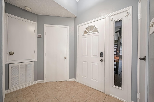 tiled entryway with a textured ceiling