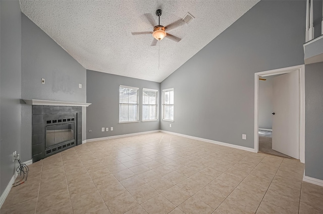 unfurnished living room featuring a tiled fireplace, a textured ceiling, ceiling fan, and light tile patterned flooring