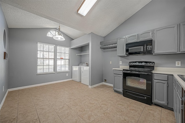 kitchen with gray cabinets, lofted ceiling, washing machine and clothes dryer, and black appliances