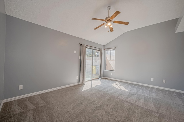 spare room with vaulted ceiling, carpet flooring, a textured ceiling, and ceiling fan