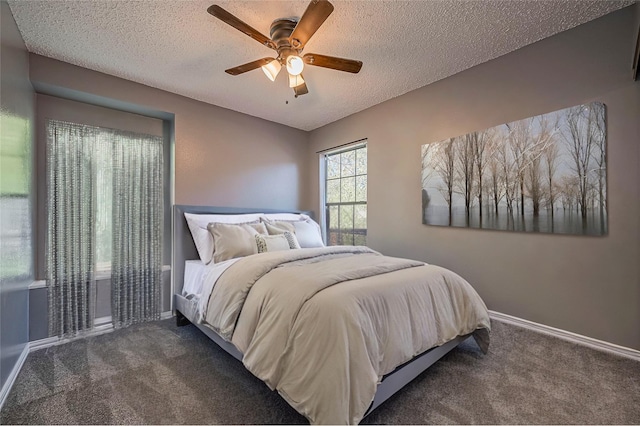 bedroom with ceiling fan, dark carpet, and a textured ceiling