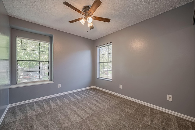 empty room with ceiling fan, carpet flooring, and a textured ceiling