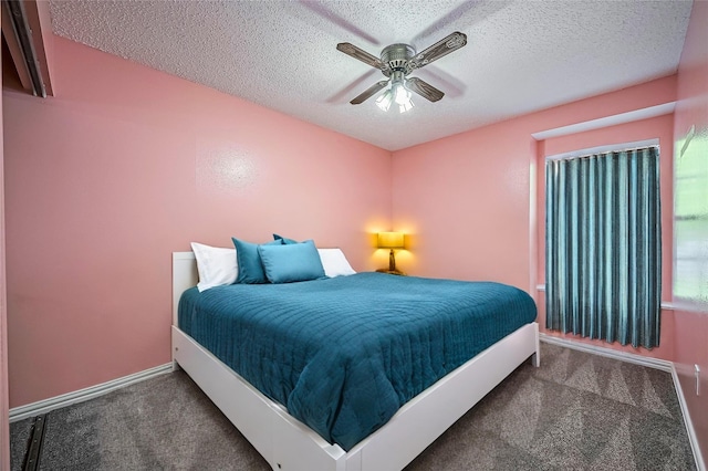 bedroom with ceiling fan, a textured ceiling, and dark colored carpet