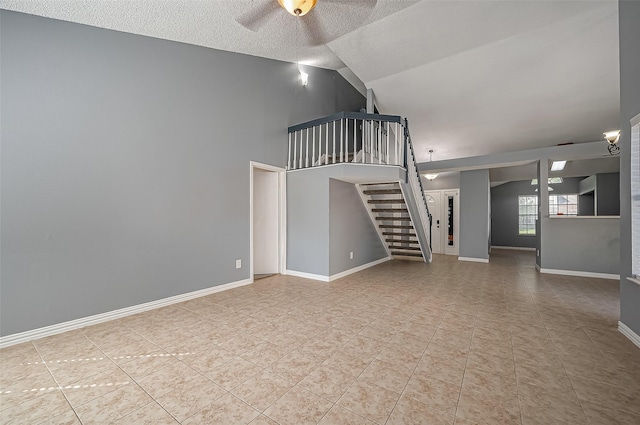 unfurnished living room featuring light tile patterned flooring, ceiling fan, high vaulted ceiling, and a textured ceiling