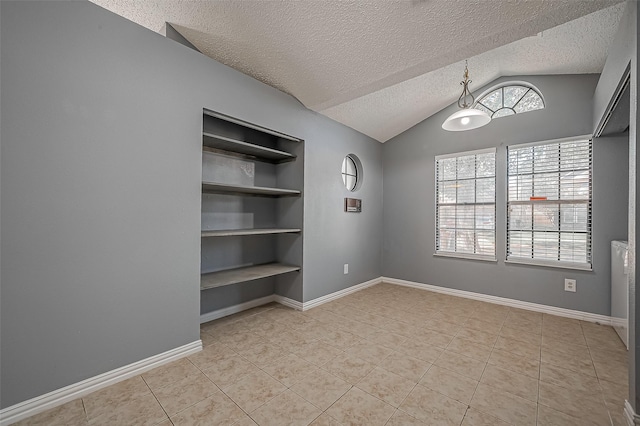 tiled empty room featuring vaulted ceiling, built in features, and a textured ceiling