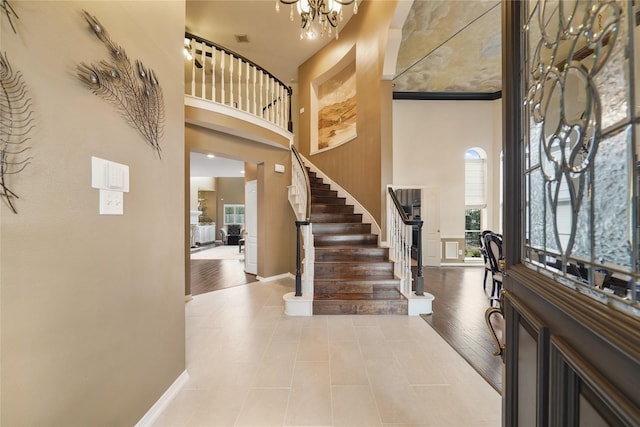 foyer entrance with a notable chandelier, a towering ceiling, and wood-type flooring