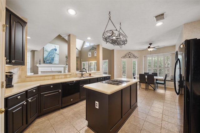 kitchen with sink, black appliances, a kitchen island, decorative backsplash, and vaulted ceiling