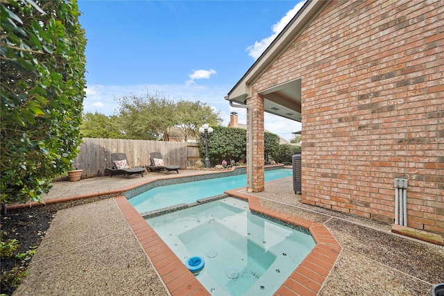 view of pool with an in ground hot tub and a patio