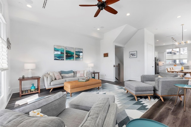 living room with dark wood-type flooring and ceiling fan with notable chandelier