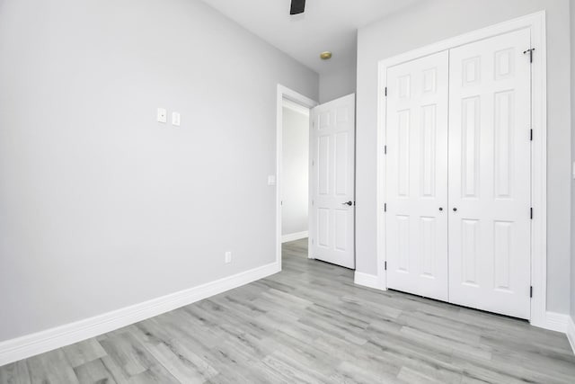 unfurnished bedroom featuring a closet, ceiling fan, and light wood-type flooring