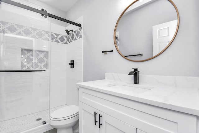 bathroom with vanity, toilet, and a shower with shower door