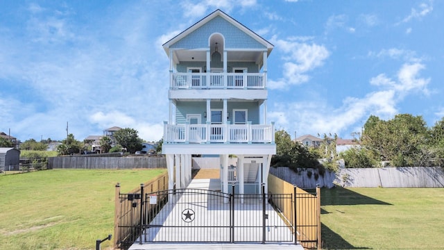 raised beach house featuring a front yard and a balcony