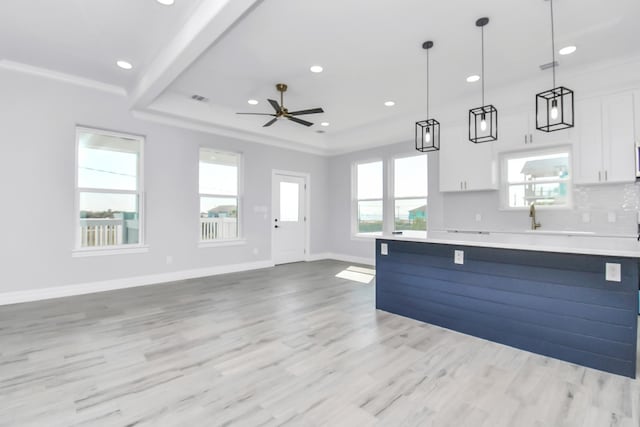 kitchen with pendant lighting, white cabinetry, and a healthy amount of sunlight