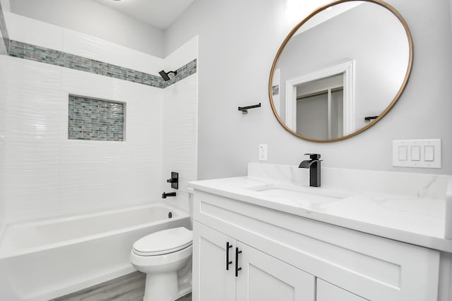 full bathroom with vanity, hardwood / wood-style floors, tiled shower / bath combo, and toilet