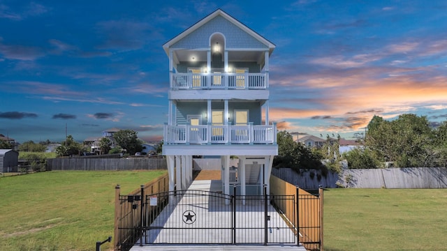 raised beach house with a balcony and a yard