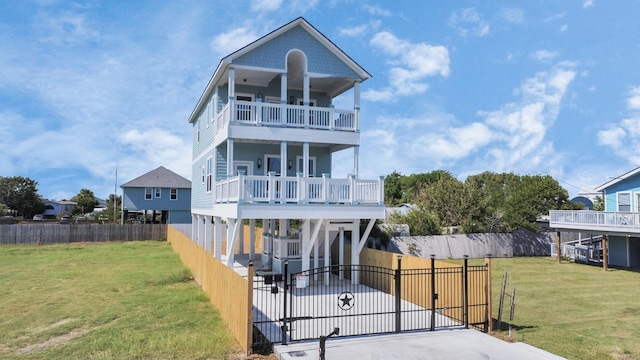 view of front of house with a carport, a balcony, and a front lawn