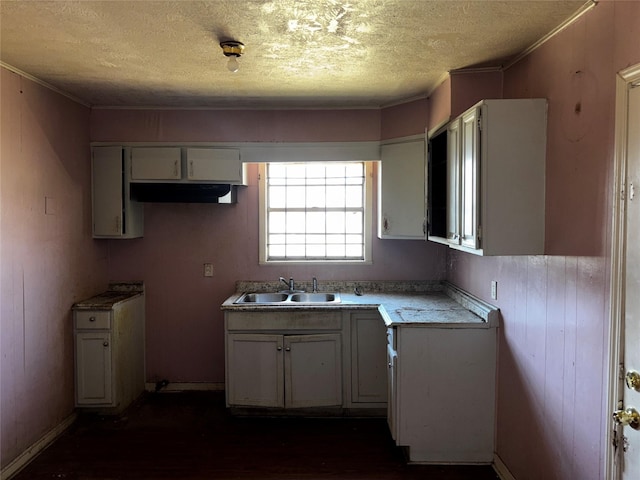 kitchen with sink, crown molding, a textured ceiling, white cabinets, and dark hardwood / wood-style flooring