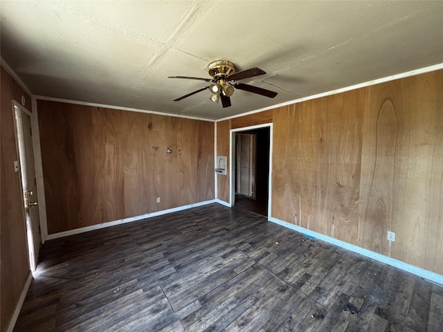 unfurnished bedroom with crown molding, dark wood-type flooring, wooden walls, and ceiling fan