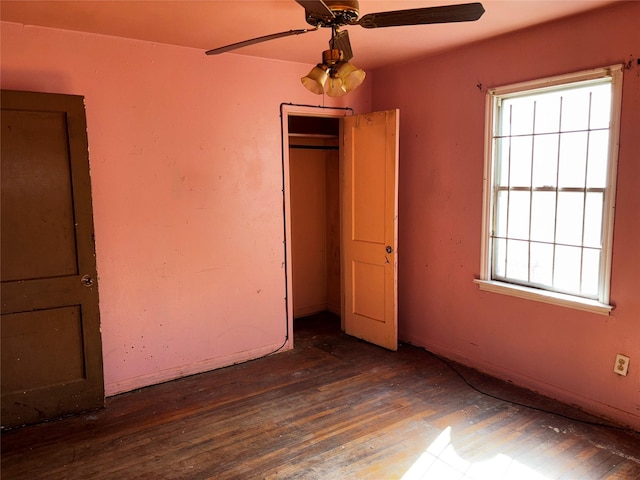 unfurnished bedroom with multiple windows, a closet, dark hardwood / wood-style floors, and ceiling fan