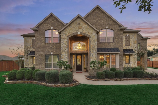 french country inspired facade featuring a yard