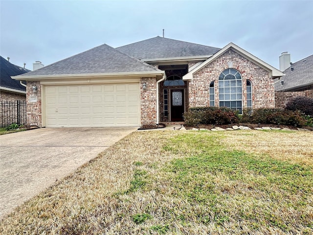 single story home with an attached garage, brick siding, concrete driveway, roof with shingles, and a front lawn