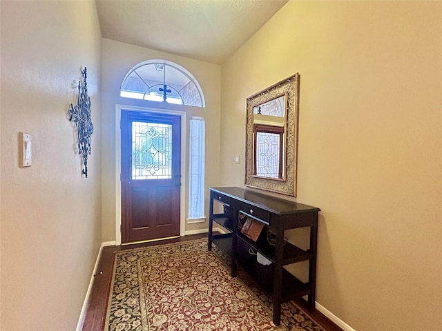 foyer entrance featuring dark wood finished floors and baseboards